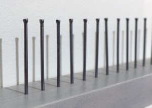 Detail image of wall hung "Impotent II" sculpture created using nails hammered into wood